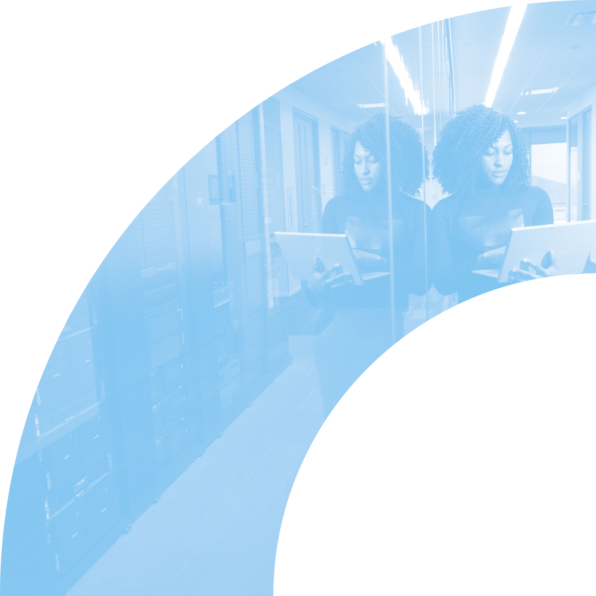 Eine IT-Spezialistin in einem Serverraum, die mit einem Laptop arbeitet, spiegelt sich in einer Glaswand – symbolisiert Technologie und Datenmanagement.