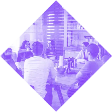 Team diskutiert in einer modernen Büroumgebung, stilisiert als diamantförmige Darstellung – symbolisiert Zusammenarbeit und kreative Perspektive.