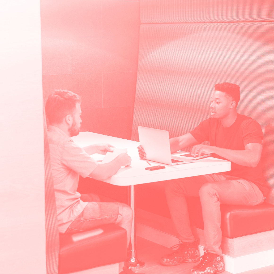 Zwei Mitarbeiter bei einer Beratungssitzung in einer modernen Arbeitsumgebung, mit einem Laptop auf dem Tisch – symbolisiert Consulting und individuelle Lösungsfindung.