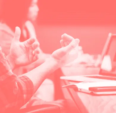 Nahaufnahme einer Handbewegung während einer Diskussion, mit Fokus auf ausdrucksstarke Kommunikation – symbolisiert Ideenaustausch.